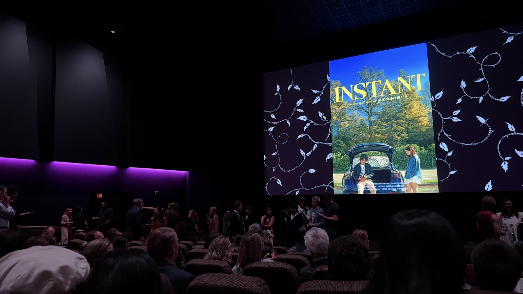 The Instant poster on a cinema screen in front of a seated festival audience